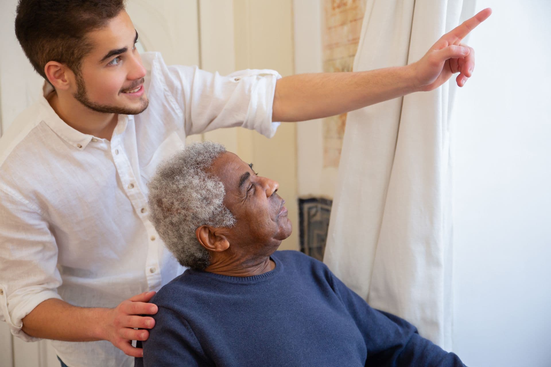 Caregiver having a warm conversation with elderly patient at home